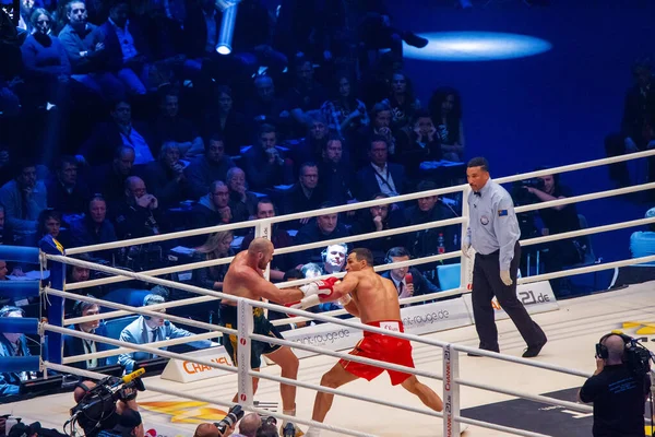 11-25-2015. Klitschko ünlü sol yumruğunu indirmeye çalışsa da, Fury kolundan hızla dalıyor ve ringin köşesinden kaçıyor. Seyirci olarak eğlenceli sunucu Michael Buffer.