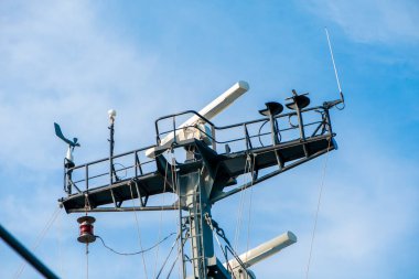 Açık mavi gökyüzünde gemi anten ve navigasyon sistemi.