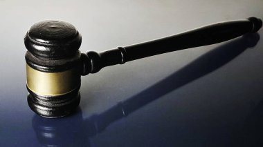 Hakimin ahşap Gavel 'i. Bandosu Yansıtıcı Mavi Yüzeyde Uzanıyor.