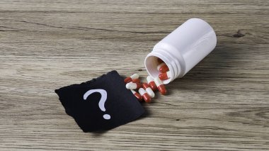 İlaç Şişesi, Kapsül ve Tahta Arkaplan ile Tedavi Soruları ve Tedavi Seçimi Konsepti