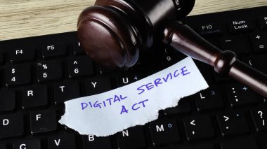 Sayısal Hizmet Yasası (DSA) kavramı, bilgisayar klavyesinde yargıç tokmağı ve el yazısıyla yazılmış bir notla çevrimiçi düzenlemeyi ve teknoloji hukukunu sembolize eder.