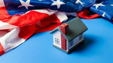 Amerika Birleşik Devletleri Emlak Piyasası Federal Konut Politikası ve Amerikan Ev Sahipliği Rüyası 'nı simgeleyen Bir Amerikan Bayrağının Önünde Dinlenen Minyatür Model Evi