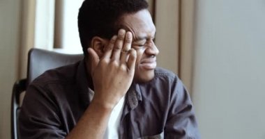 Baş ağrısı çeken yorgun Afro-Amerikan ofis çalışanı öğrenci patronun portresi. Stresli siyah adam acı çekiyor ve masaj yapıyor. Rahatlamak ve kapalı alandaki ağrıyı azaltmak için, vesikalık fotoğrafı yakın.