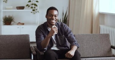 Yalnız, gevşemiş, Afro-Amerikan bir adam evdeki kanepede oturmuş televizyon seyrediyor, kollarını kaldırıyor heyecandan duygusal çığlıklar atıyor ve zafer zaferini kutluyor.