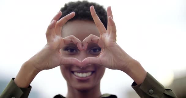 Portret van lachend gemengd ras tiener meisje zet handen voor het gezicht, vouwt vingers in hartvorm, toont teken van liefde romantiek, maakt grappige masker bril met handen, sympathie vriendelijkheid concept — Stockvideo