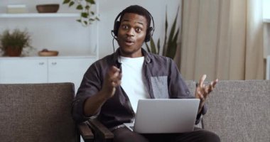 Kulaklık takan Afrikalı adam evde oturup mesaj atıyor dizüstü bilgisayar kullanıyor. Kariyerinde ilerleyen hisse senedi satışları hakkında haber e-postası alıyor. Online piyango kazanıyor. Afro öğrenci sınav sonuçlarını alınca mutlu oluyor.