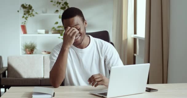 Africano chico sentarse en el escritorio en la habitación en casa trabajando en el ordenador portátil leer e-mail recibido grandes noticias se siente emocionado increíble feliz. Estudiante hombre ganar subasta apuestas lotería en línea, momento de emociones sinceras — Vídeos de Stock