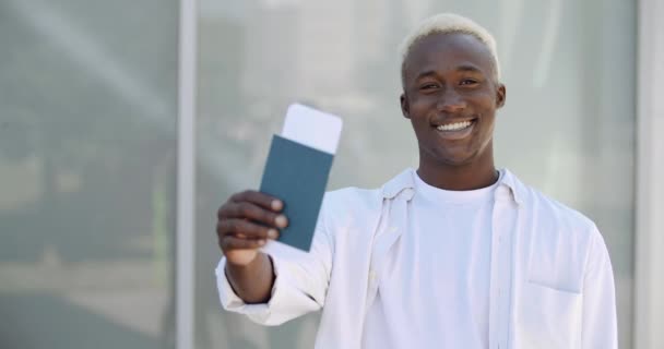 Portret młodego afrykańskiego studenta amerykańskiego turysty nastolatka atrakcyjny macho mężczyzna w białych ubraniach stoi na lotnisku terminalu na świeżym powietrzu pokazuje bilet lotniczy i paszport do kamery raduje wakacje — Wideo stockowe