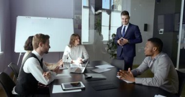 Çok ırklı iş adamlarından oluşan çok ırklı grup, Afrikalı yatırımcı ile Kafkasyalı lider yönetici arasındaki diyaloğu dinliyor. Profesyonel pazarlama finansörlerinden oluşan bir ekip mevcut projede toplantıda.