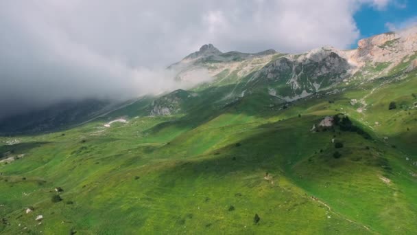 Vue aérienne du magnifique paysage montagneux sous des nuages montagneux, jetant l'ombre sur la vallée verte de flanc de montagne. Belle nature du Caucase à partir de la hauteur dans la République d'Adygea, Russie. — Video