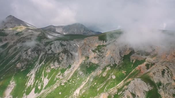 Эпический утренний горный пейзаж с травой, покрытой склоном под движущимся паром облаков. Вид с воздуха на красивые Кавказские горы. Чудесное место для посещения туристами. Концепция путешествия и походов — стоковое видео