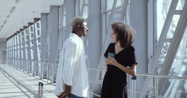 Homme africain montre billet d'avion fille pour le voyage à l'étranger en vacances mixte femme étreint son mari tendrement avant le vol pour la lune de miel, deux personnes se sentent heureux tout en se tenant debout dans le terminal de l'aéroport — Video