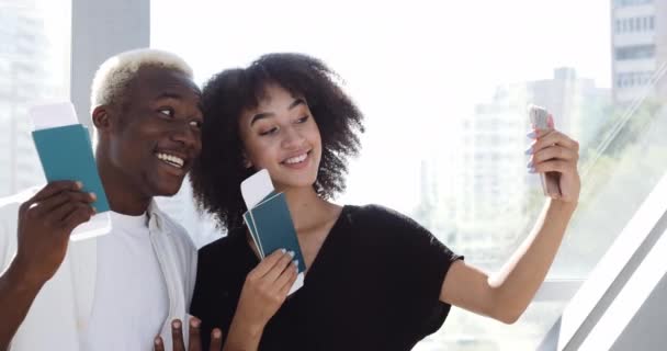 Δύο έφηβοι αφρικανοί άνδρες και αμερικανίδα γυναίκα στέκεται μαζί στον τερματικό σταθμό του αεροδρομίου λήψη selfie φωτογραφία με εισιτήρια στην κάμερα smart phone για το κοινωνικό δίκτυο πυροβολούν ταξίδι βίντεο για το blog — Αρχείο Βίντεο