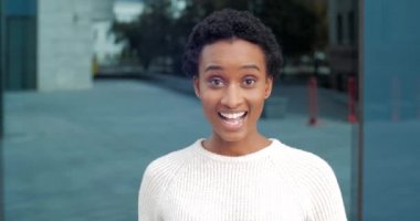 Hevesli duygusal kız Afrikalı Amerikalı öğrenci binanın arka planında tek başına duruyor işaret parmaklarıyla yönünü gösteriyor yakın çekim seçeneğini gösteriyor.