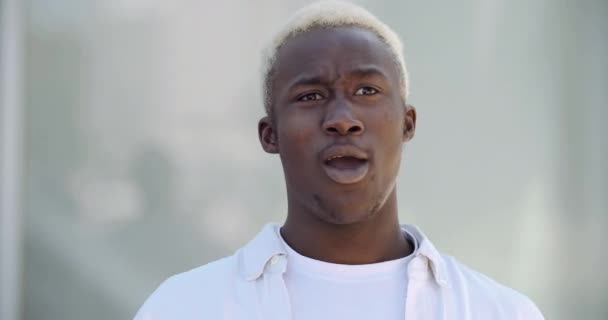 Head shot afroamericano misto uomo razza indossa vestiti bianchi camicia casual chiamata dà il benvenuto agitando le mani amichevoli parlando. Faccia da uomo emotivo. nero ragazzo studente adolescente stand all'aperto parlando — Video Stock