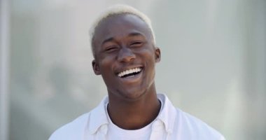 Açık havada kamerayla konuşan ve gülümseyen Afro-Amerikan gencin portresi. Yakın çekim etnik erkek yüzü, karışık ırk blogcusu önünde gülerek konuşuyor.
