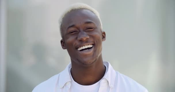Egy barátságos, széles mosolygós fiatal srác portréja afro-amerikai tinédzser férfi áll a szabadban, és kamerába beszél. Közelkép etnikai férfi arc, vegyes fajú blogger, aki nevetve néz az orra elé. — Stock videók