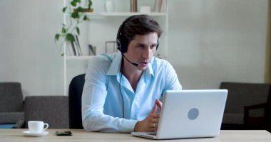 Ciddi bir öğretmen patronuyla aynı masada oturuyor, uzaktan çalışıyor, video konferansında web kamerasında iletişim kuruyor, müşteri ile sohbet ediyor, dizüstü bilgisayar kullanıyor, karantinada iş yapıyor.