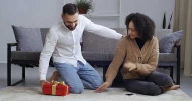 Kafkas erkeği kocası, oturma odasındaki kanepenin yanında oturan Afrikalı Amerikalı kadının gözlerini kapar erkek arkadaşı sevgilisine Noel 'de sevgililer günü için sürpriz yapar.