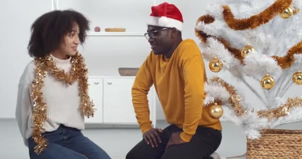 Sorridente donna afro americana congratularsi con il suo fidanzato saluto con Capodanno con scatola regalo rossa. Felice amorevole giovane moglie riccia fare sorpresa dare regalo di Natale al marito che celebra le vacanze invernali — Video Stock