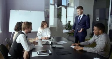 İş dünyası profesyonel yöneticileri ofis konferansında oturup Lider 'in başarılı proje analizi raporunu dinleyerek beyin fırtınası yapan maliyetleri analiz ediyorlar. Beyaz adam brifing veriyor.