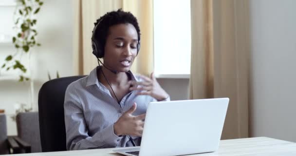 Framgångsrik afro amerikansk flicka affärskvinna manager operatör assistent bär huvud mikrofon hörlurar råda kunder på distans från kontoret hem talar webbkamera kommunicerar online under karantän — Stockvideo