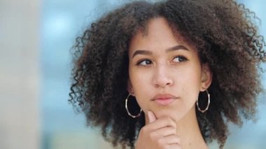 Güzel yüzü yakından gören Afro-Amerikan genç kadın yoğun bir şekilde düşünen sorun, çene ovuşturma, yan yana şaşı gözler, çatık kaşlar, dikkatlice düşünme, anlayış ve fikir keyifle geliyor.