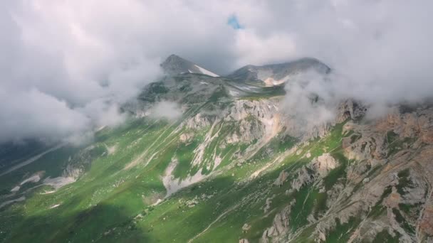Epische ochtend verbazingwekkende berglandschap onder bewegende grote wolken in de zomer zonnig weer, Adygea, Rusland. Luchtfoto van bergen met sneeuw en gras. Prachtige natuur van de Kaukasus vanaf hoogte. — Stockvideo