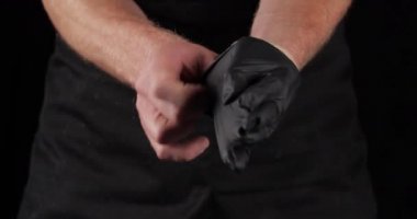 Beyaz erkek cerrah doktor ya da profesyonel şef siyah lateks eldiven giyer deriyi bakteri virüslerinden korur mutfak restoranında çalışmaya hazırlanır ya da hamburger yer, erkek eli yakın çekim yapar.