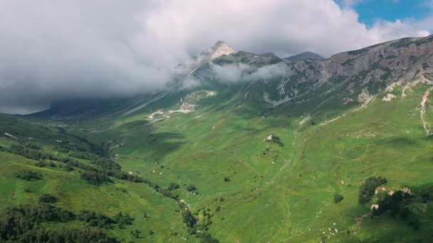 Vista aérea deslumbrante do vale maravilhoso com paisagem montanhosa sob nuvens subindo na manhã épica no verão de Adygea, Rússia. Vista superior de espetaculares montanhas caucasianas com florestas e encostas. — Vídeo de Stock