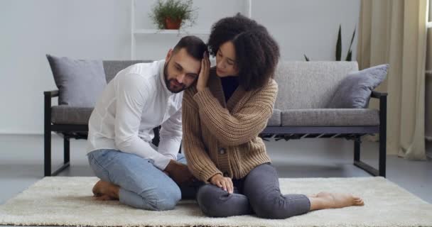 Joven afroamericano negro mestizo mujer esposa apoya blanco caucásico hombre triste chico molesto novio marido sintiendo estrés pena, pareja abrazo. Lady acariciando la cabeza confortablemente, ayudar a apoyar el concepto — Vídeo de stock