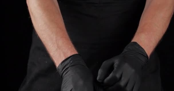 病院、シェフや医師における衛生調理のための彼の手の上にゴムラテックス黒手袋を入れて調整する男のクローズアップ制服クロップドフレーム、プロの服 — ストック動画