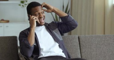 Cep telefonuyla konuşan Afro-Amerikalı adamın portresi, evdeki kanepede oturarak, problem ve çözüm kavramını anlatarak, telefonla ilgili bilgileri açıklıyor.