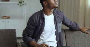 İlgilenen meraklı Afro-Amerikan siyah ırkçı adamın portresi. Kanepede oturmuş, pencereden dışarıdaki birine bakıyor. Yüzündeki düşünceli ifadeyi fark etmeye çalışıyor.