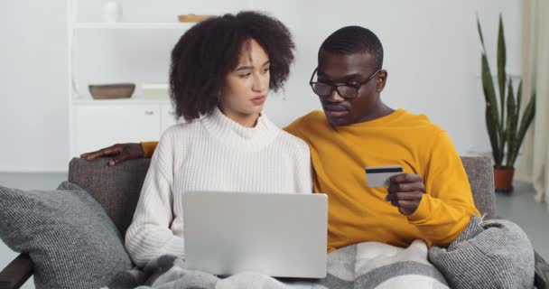 Afro american family young pair makes online buy orders delivery book ticket internet payment via laptop using bank card take credit transfer money to καραντίνα απομόνωση, πανδημία έννοια — Αρχείο Βίντεο