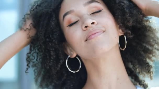 Feliz mujer africana étnica americana de buen humor cierra los ojos disfruta de la vida. Chica estudiante joven satisfecha con pecas, pelo afro rizado, sonriente relaja al aire libre, respira profundamente libremente aire fresco — Vídeos de Stock