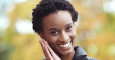Afro kadın mutlu yüzün yakın çekimi. Pozitif Afro-Amerikan kız portresi dişlek gülümseyen siyah kadın kameraya bakıp yalnız poz veriyor. İstek üzerine katlanmış eller.