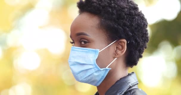 코로나 바이러스에 대한 의료용 마스크를 착용하고 있는 미국 여성의 얼굴은 세계적 인 전염병이 발생하는 동안 야외에서 고립되어 있다. — 비디오