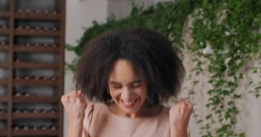 Yakın plan portre güzel bin yıllık yabancı öğrenci kıvırcık saçlı Amerikalı kadın kameraya bakarak iyi haberler alıyor sevinç hissediyor mutluluk ağızları açıyor zafer dansları kazanıyor