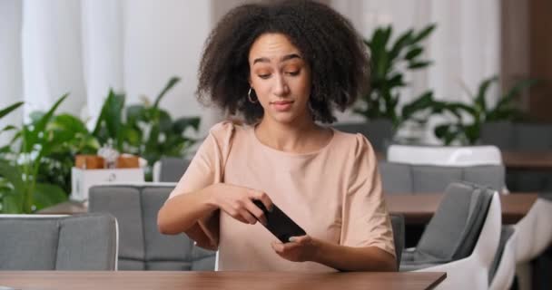 Portré fókuszált fiatal afro amerikai nő fekete lány tinédzser göndör frizura játék online játék segítségével telefon üvölt érzés bánat stressz tartja a fejét a szomorúság, kudarc koncepció — Stock videók