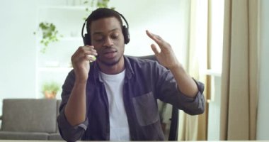 Evinden uzaktan ders çalışan Afrikalı Amerikalı bir öğrencinin webcam görüntüsü. Karışık ırk işadamlarına, müşterilerine kulaklık takmalarını ve öğretmenlere çevrimiçi ders, destek hattı konsepti öneriyor