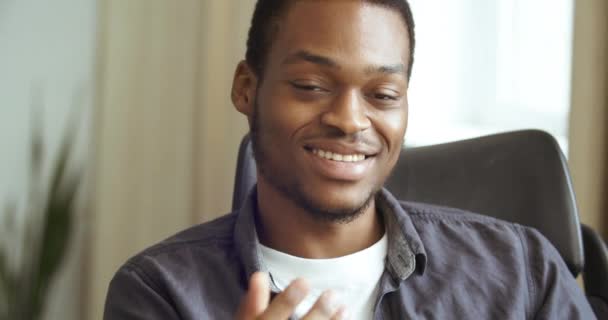 Close-up cropped shot jong gezicht van Afrikaanse Amerikaanse man zakenman student op zoek naar camera oprecht beantwoorden vraag spreekt tot webcam volgens schudt zijn hoofd, mannelijk portret front view — Stockvideo