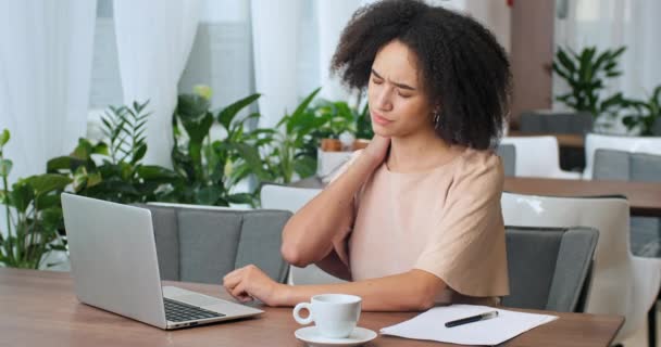 Side view νεαρή επιχειρηματίας γυναίκα μικτή κυρία χιλιετή αλλοδαπός αφροαμερικανός φοιτητής freelance πενιχρή εργασία εξ αποστάσεως στο καφέ αίσθημα πονοκέφαλο που πάσχουν από πόνο στην πλάτη κόπωση άγχος πίεση — Αρχείο Βίντεο