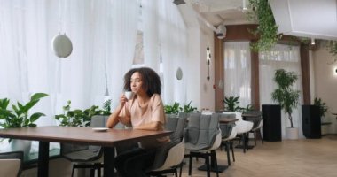Uzun vadede, kıvırcık saçlı, Amerikalı genç ve güzel bir kız. Siyah kadın pahalı lüks restoranlarda masada oturuyor. Kahve içiyor, çay içiyor.