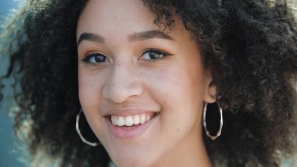 Krásná sebevědomá mladá Afričanka. Šťastná etnická americká studentka s pihami, kudrnatým afro účesem a zdravými bílými zuby. Spokojenost paní dívající se na fotoaparát s uspokojením — Stock video
