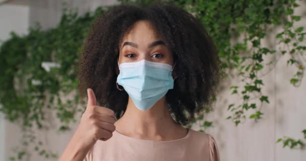 Зворотна кучерява відповідальна за хворобливу дівчинку африкано-американку жінка-підліток носить медичну захисну маску на обличчі жінки, яка страждає від алергії на інфекції дихальних вірусів. — стокове відео