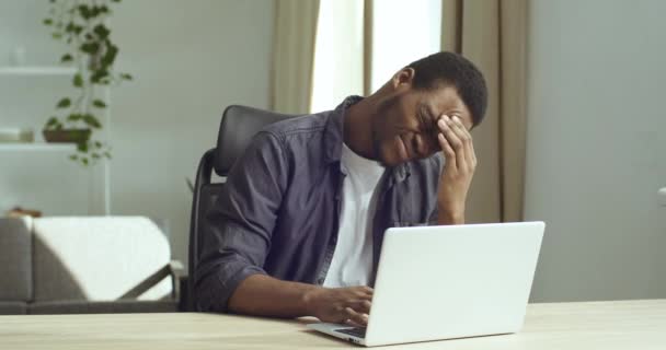 Afro american business man touching back sitting at desk feeling sudden backache pain, black tired sad guy suffering from incorrect bad posture work at laptop computer, rheumatism injury problems — Vídeo de Stock