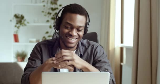 Porträtt av leende afrikansk amerikansk kille student svart vänlig glad man bär huvudet mikrofon talar till laptop webbkamera på distans kommunicerar med familj vänner under pandemisk isolering karantän — Stockvideo