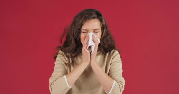 Sick caucasian girl sad millennial woman suffering from runny nose sneezes blowing her nose into white handkerchief paper napkin feels symptoms of cold flu disease, nasal virus feeling sick concept — Vídeo de stock