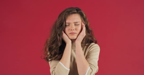 Jong mooi meisje tiener vrouw met lang haar voelt hoofdpijn houden haar voorhoofd met haar hand en masseren haar hoofd lijdt aan symptomen van chronische migraine temperatuur verhoging koorts ziekte — Stockvideo